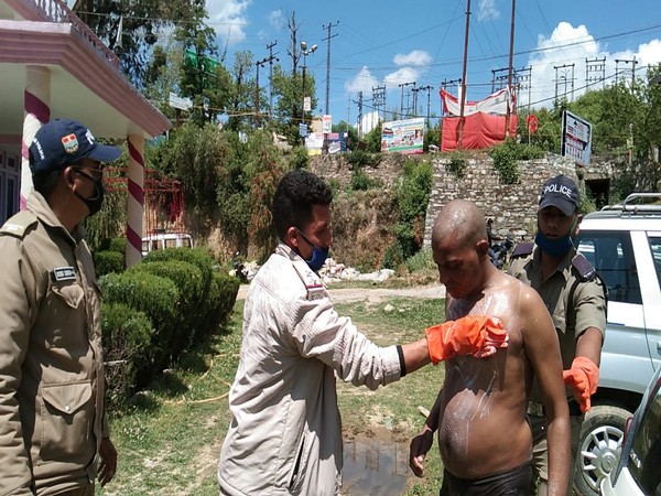 Policemen in Pithoragarh helping a mentally ill person during a lockdown [Photo/ANI]