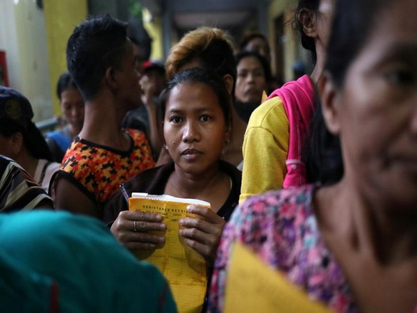 A woman waits to receive assistance at the Delpan Evacuation Center after Typhoon Kammuri hit Metro Manila.