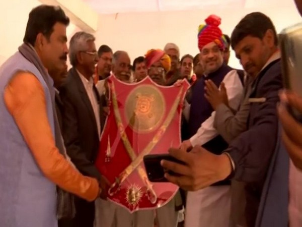Pakistani refugees in Jodhpur present a momento to Union Minister Amit Shah on Friday. (Photo/ANI)