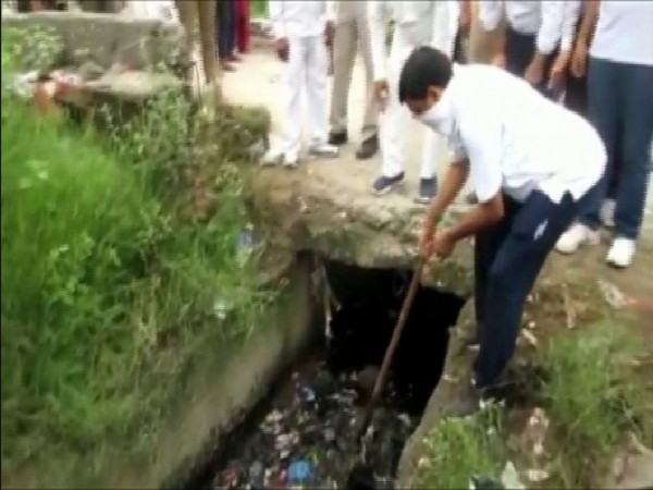 Rampur DM Anjaneya Kumar Singh engaged in cleaning a drain in Rampur on Saturday morning. Photo/ANI