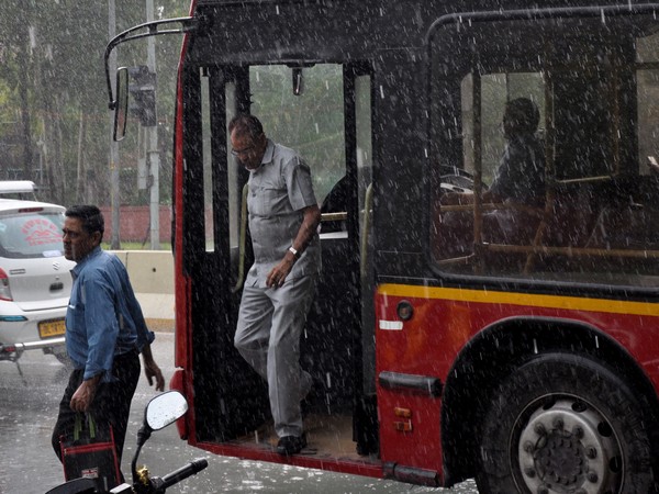  People step out from a bus as it rains in New Delhi on Monday. (ANI Photo)