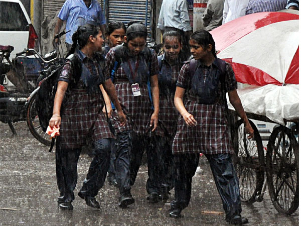  A group of schoolgirls walk during heavy rainfall in Old Delhi. (ANI Photo)