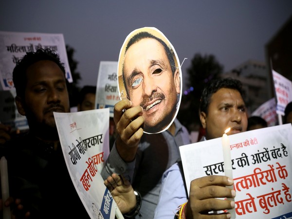 Protester holds up picture of expelled BJP legislator Kuldeep Singh Sengar (File photo)