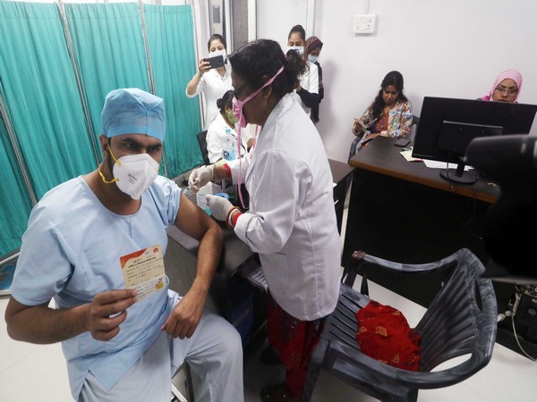 A beneficiary shows his report card as he gets COVID-19 vaccine at Eraz Medical College and Hospital, in Lucknow on Saturday.