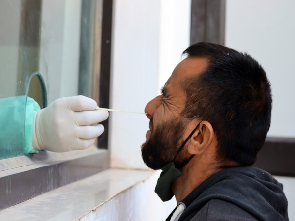 A health worker takes a sample from a man for the covid-19 test. (Photo/ANI)