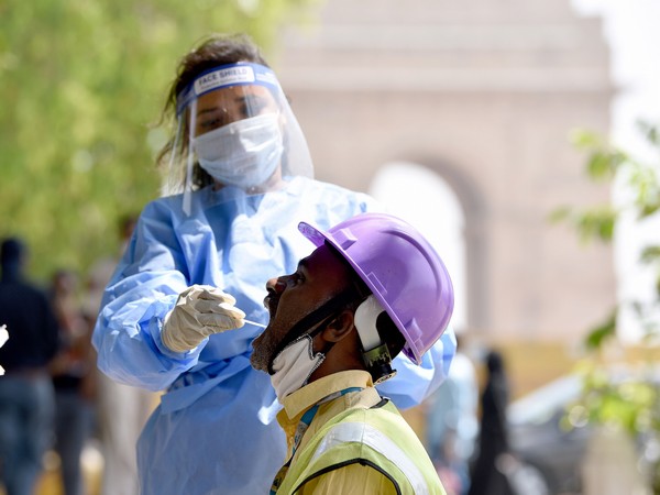 A health worker collects a swab sample from a man at a lawn near India Gate to conduct tests for the COVID-19, amid the spread of the disease in New Delhi. (Photo/ANI)