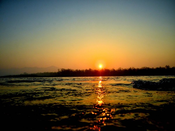 Rising sun illuminates the waters of the Ganga river on Saturday. [Photo/ANI]