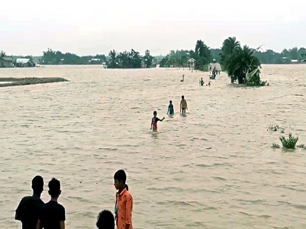 People wade through a waterlogged street triggered by incessant rainfall. (Photo/ANI)