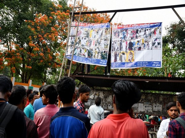 People look at posters hung by Jharkhand Police showing the pictures of accused of Ranchi violence (File photo/ ANI/ June 14)