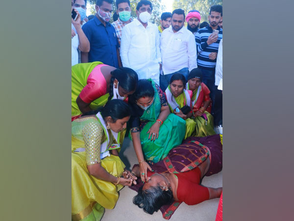 TRS leader K Kavitha helping unconscious woman on road. (Photo/ANI)