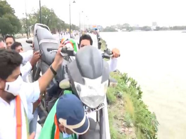 Youth Congress leaders throw a two-wheeler in Hussain sagar as mark of protest against fuel price hike in Hyderabad on Friday.