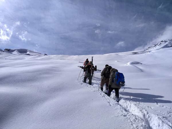 Two people crossing Rohtang pass with the help of rescue team deployed at Koksar on Tuesday. Photo/ANI