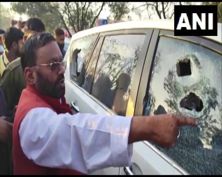 SP leader Swami Prasad Maurya points at damaged car window (photo/ANI)