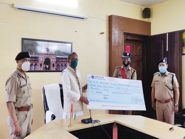 Uttrakhand police officials presented Rs 3 crore to Chief Minister Trivendra Singh Rawatto fight COVID-19 on Friday [Photo/ANI]