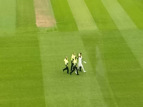 The intruder being taken off the field by security. (Photo- ANI)