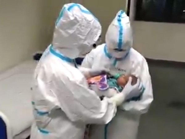 Nursing staff of Raipur AIIMS taking care of the three-month old daughter of a COVID-19 positive patient. Photo/ANI