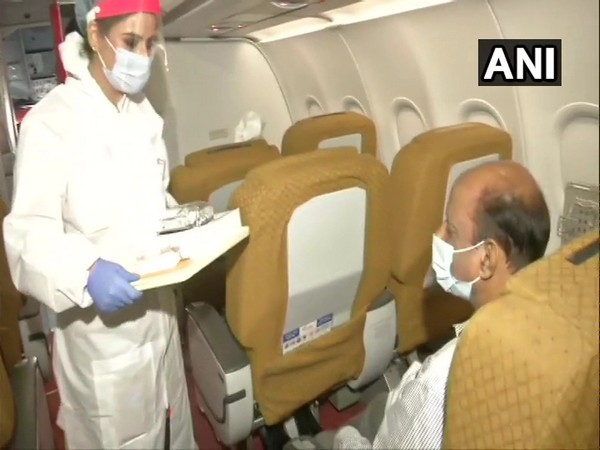 Air hostess serving food to a passenger in Air India flight. (Photo/ANI)
