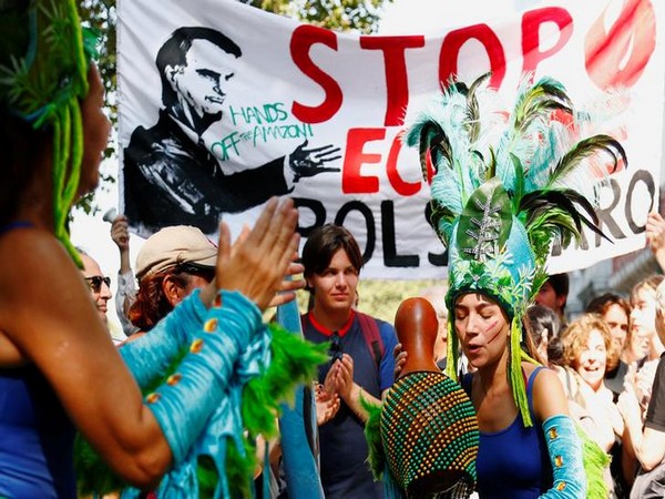 Protesters wearing Brazilian carnival costumes dance during a demonstration to demand protection for the Amazon rainforest outside the embassy of Brazil in Brussels