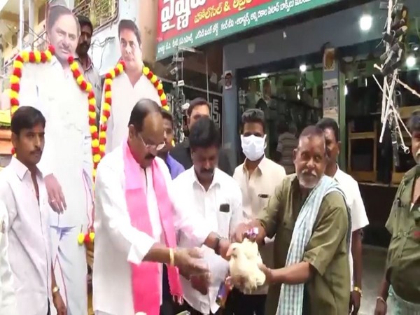Visual of TRS leader Rajanala Srihari distributing liquor and chicken (Photo:ANI)
