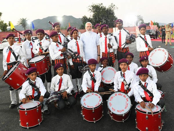 PM Modi with tribal children musical band (Image source: PIB) 