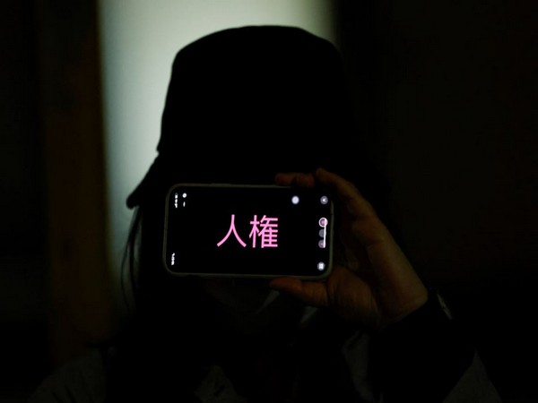 A demonstrator holds a phone with a sign reading 