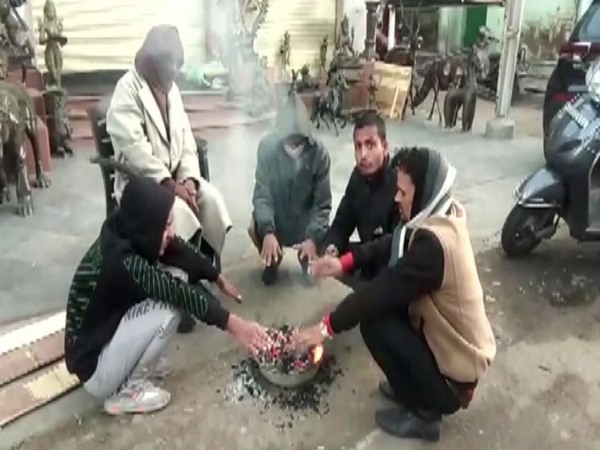 People gather around a bonfire as temperature dips at Mount Abu (Photo/ANI)