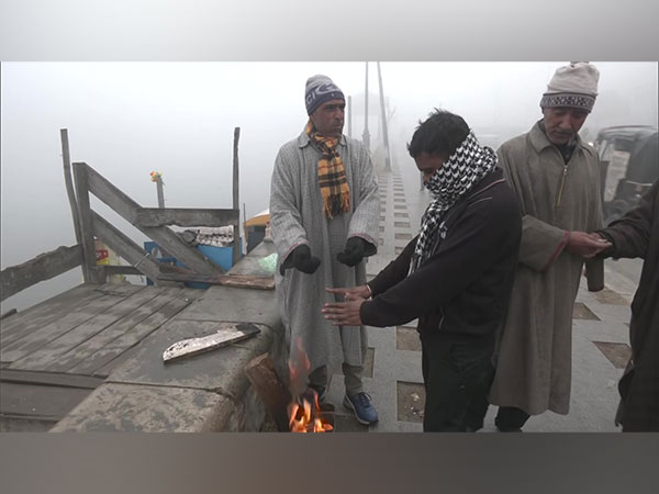 People gather around bonfire in Srinagar (Photo/ANI)