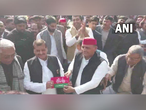 SP Chief Akhilesh Yadav presented a party flag to his uncle Shivpal Singh Yadav in Saifai (Photo/ANI)