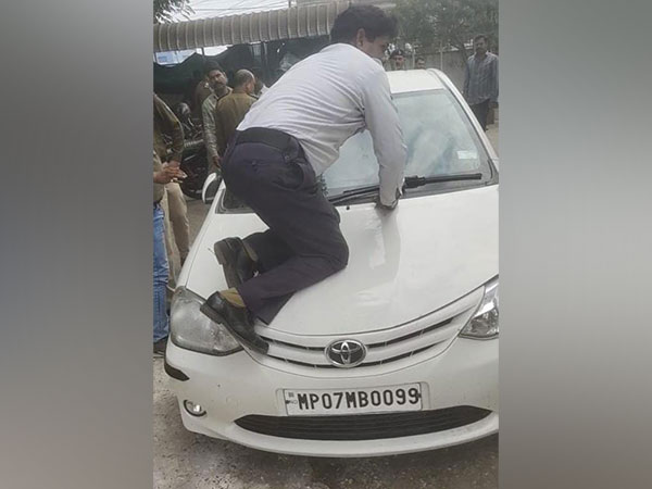 Traffic head constable Shiv Singh on Car bonnet (Photo/ANI)
