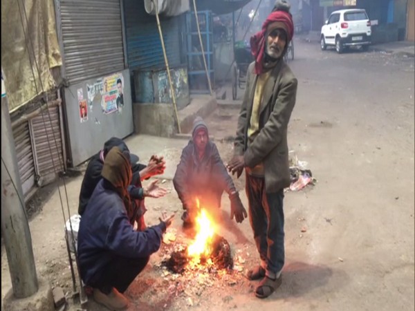 People huddle around bonfire in Kanpur. (Photo/ANI)