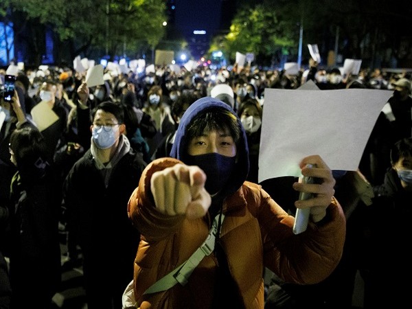 People hold white sheets of paper in protest over COVID-19 restrictions, Beijing, China, November 27. (Photo Credit: Reuters)