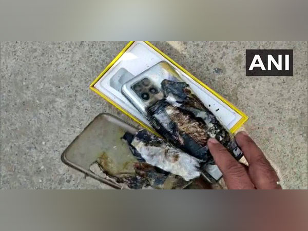 Amroha youth shows his exploded mobile.( Photo/ANI)