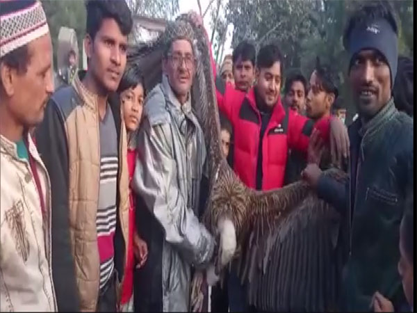 Villagers with the vulture in Kanpur. (Photo/ANI)