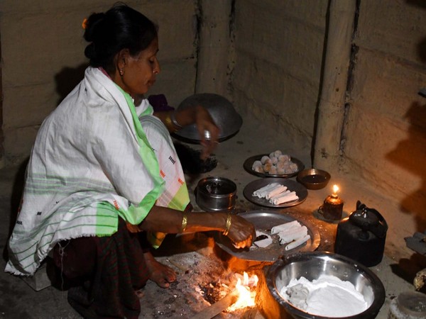 People preparing traditional food 'pitha' on Bhogali Bihu festival in Assam. (ANI/phpto)