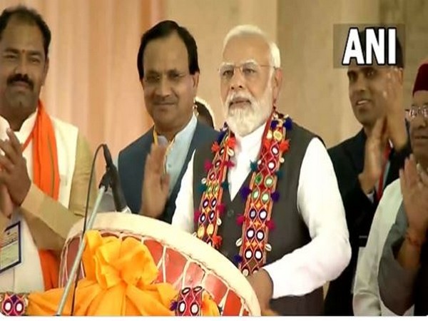 PM Narendra Modi tries his hands at traditional drum during public rally in Karnataka's Kalaburagi (Photo/ANI)