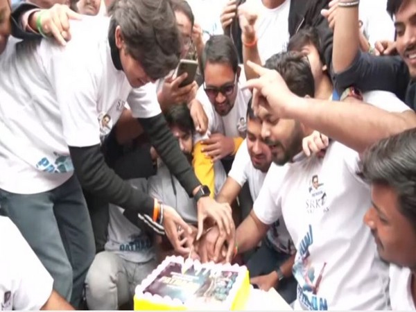 Fans cut cake to celebrate Shah Rukh Khan's film 'Pathaan' in Patna. (Photo/ANI)