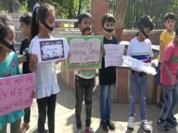 Children with black gags hold up placards and banners in Vadodara (Photo/ANI)
