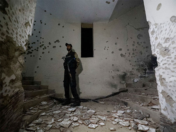 A police officer secures a site as he stands amid the damages in the aftermath of an attack on a police station in Karachi. (File Photo/Reuters)