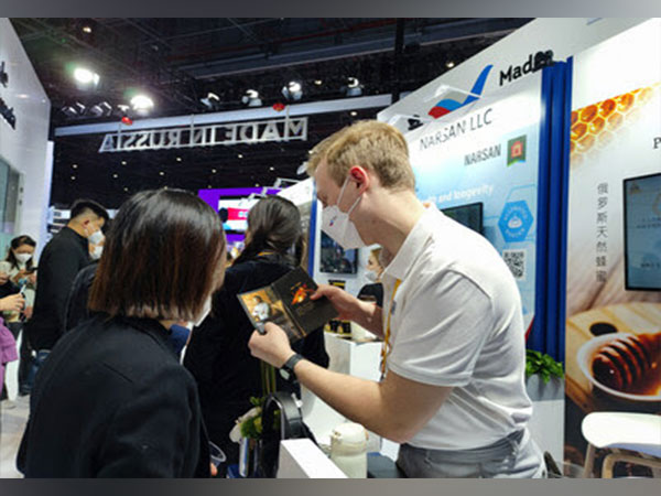 An exhibitor (right) introduces products to visitors at his booth during the fifth China International Import Expo.