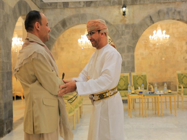 The head of the Houthi Supreme Political Council, Mahdi al-Mashat, shakes hands with an Omani official at the Republican Palace in Sanaa (Image Credit: Reuters)