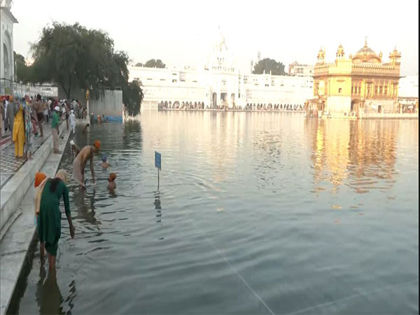 Devotees take holy dip in 'sarovar' at Golden Temple in Amritsar. (Photo/ANI)