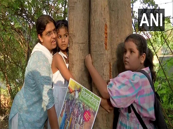 Locals hug trees in a protest against Pune's Riverfront development Project. (Photo/ANI)