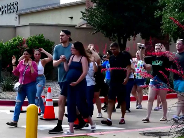 Shoppers leave with their hands up after police responded to a gunman at Allen Premium Outlets. (Photo Credit - Reuters)