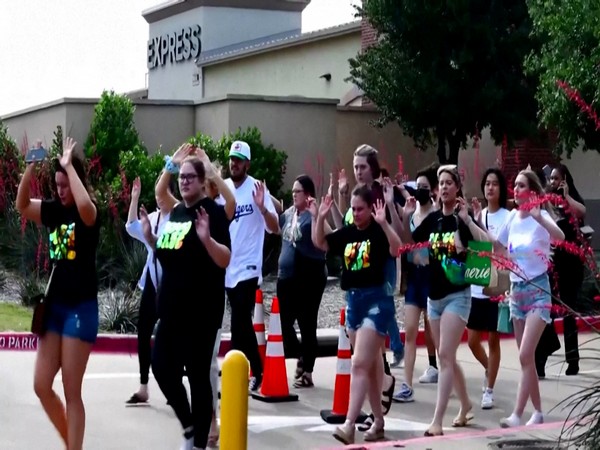 Shoppers leave with their hands up after police responded to a gunman at Allen Premium Outlets. (Photo Credit - Reuters)