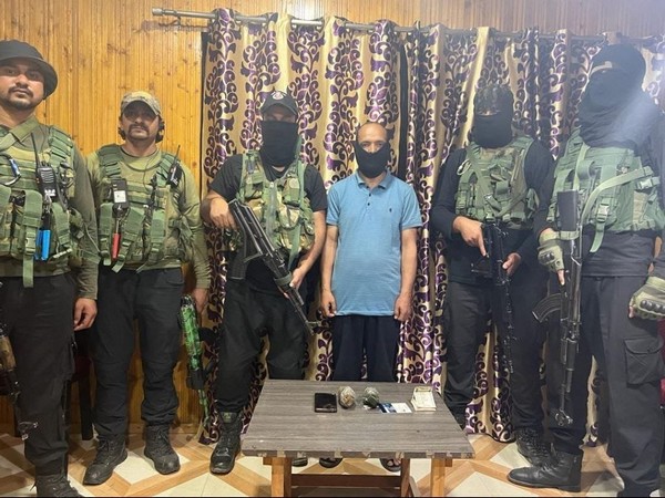 Security force officials with arrested terrorist associate (Photo/ANI)