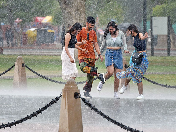 People enjoying amid heavy rain at Kartavya Path in New Delhi. (Photo/ANI)