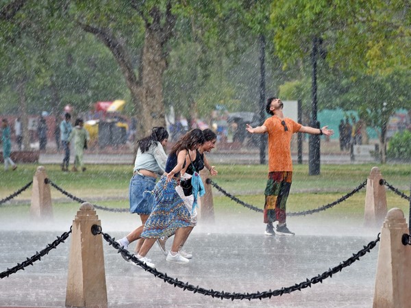 People enjoy during a rain, near India Gate in New Delhi. (Photo/ANI)