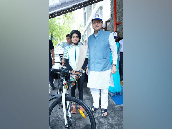 Uttarakhand Chief Minister Pushkar Singh Dhami with Cyclist Asha Malviya (Photo/ANI)