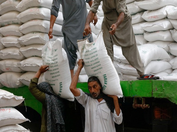 Labourers unload bags of sugar from a delivery truck to a wholesale market in Karachi, Pakistan. (File Photo/Reuters)
