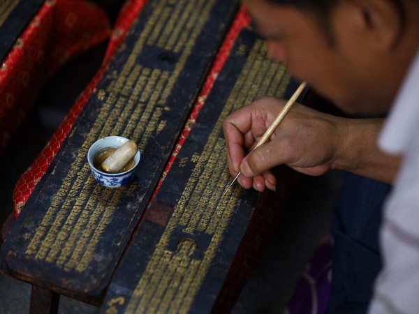 An artist repaints Buddhist manuscript with gold (Photo/ANI)
